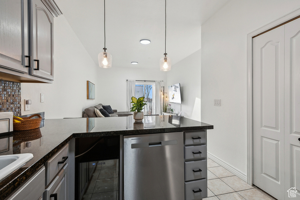 Kitchen with gray cabinetry, decorative light fixtures, light tile patterned floors, a peninsula, and stainless steel dishwasher