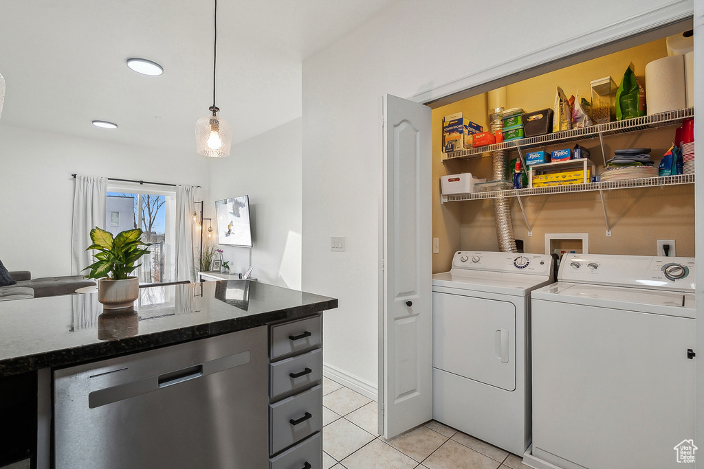 Laundry room featuring washer and clothes dryer, laundry area, and light tile patterned flooring