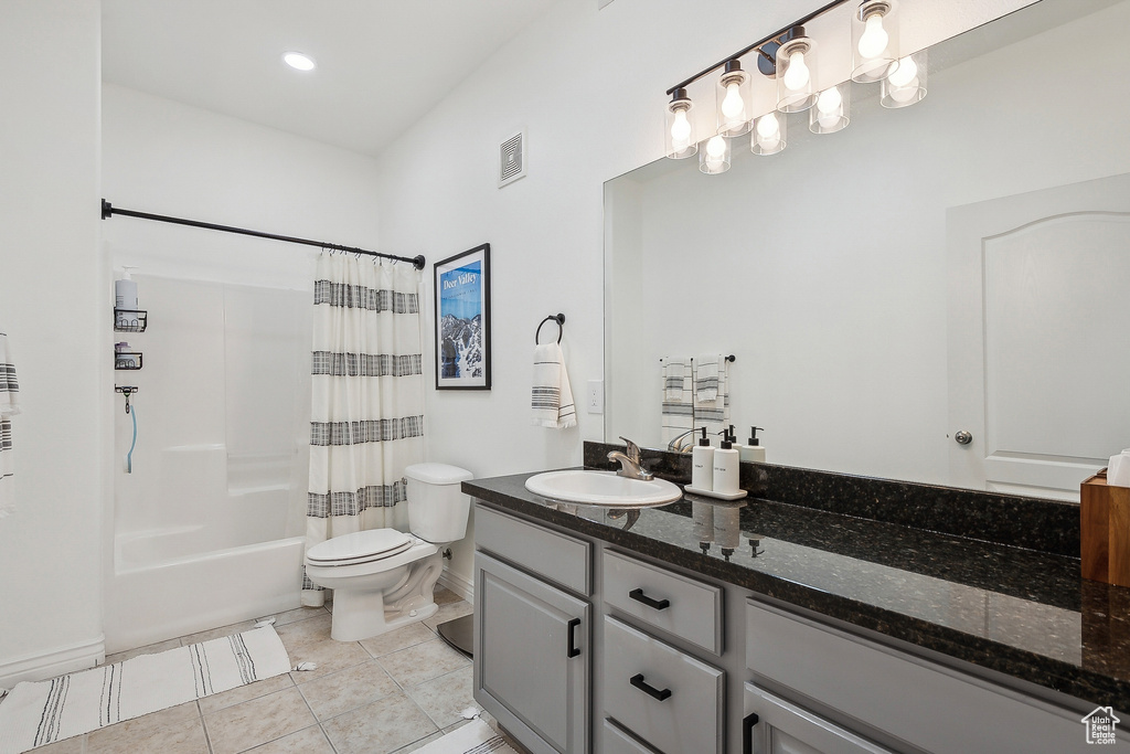 Full bath featuring tile patterned floors, visible vents, shower / bathtub combination with curtain, toilet, and vanity