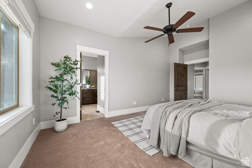 Bedroom with baseboards, carpet floors, lofted ceiling, ceiling fan, and ensuite bathroom