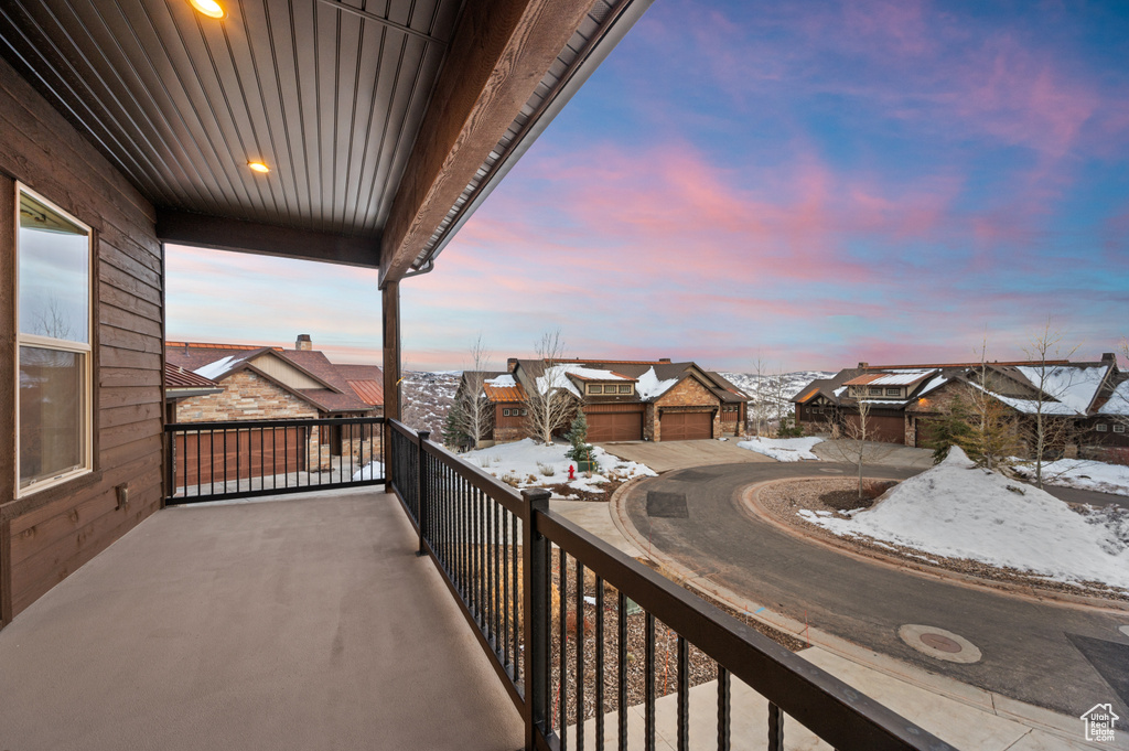 Snow covered back of property featuring a residential view