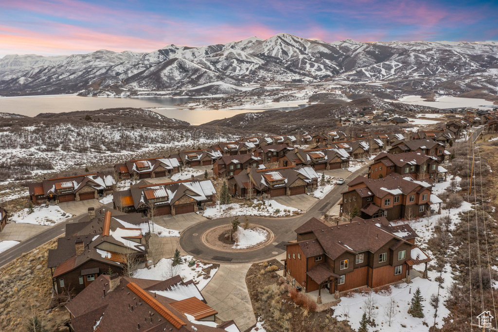 Snowy aerial view featuring a mountain view and a residential view