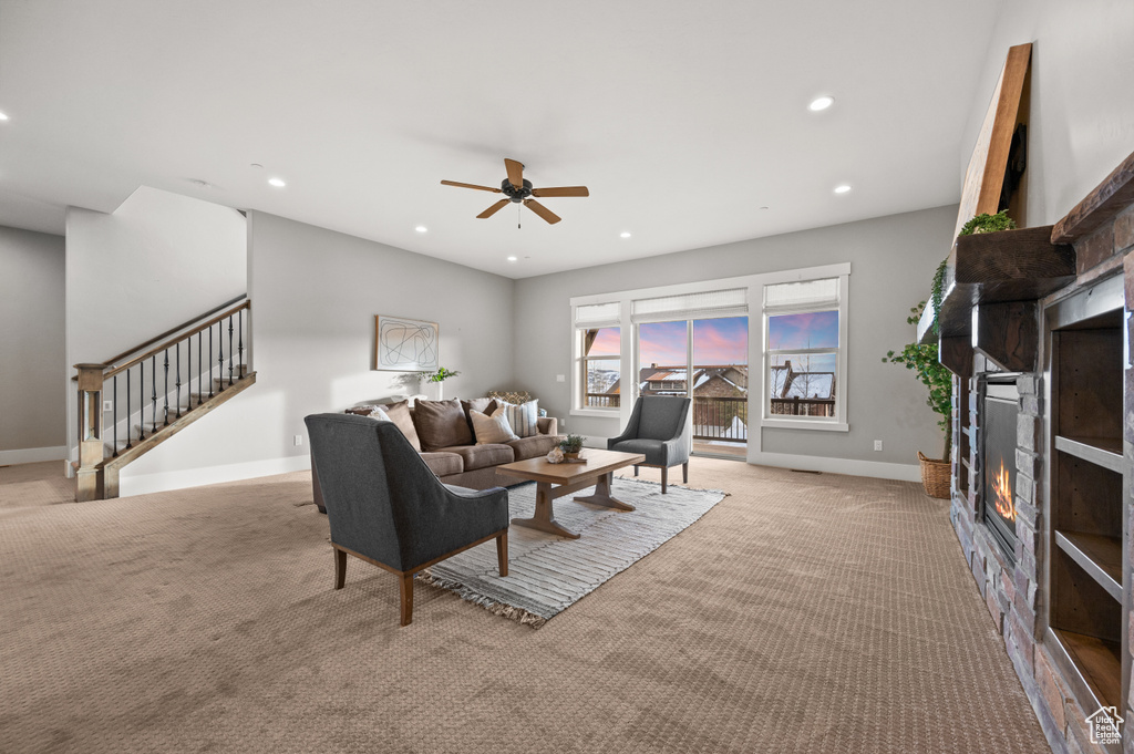 Living room featuring stairway, carpet, baseboards, recessed lighting, and a glass covered fireplace