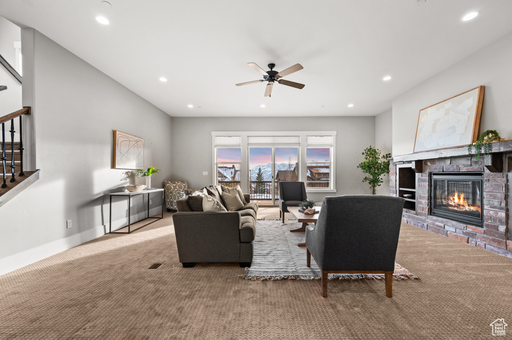 Carpeted living room with recessed lighting, a fireplace, baseboards, and a ceiling fan