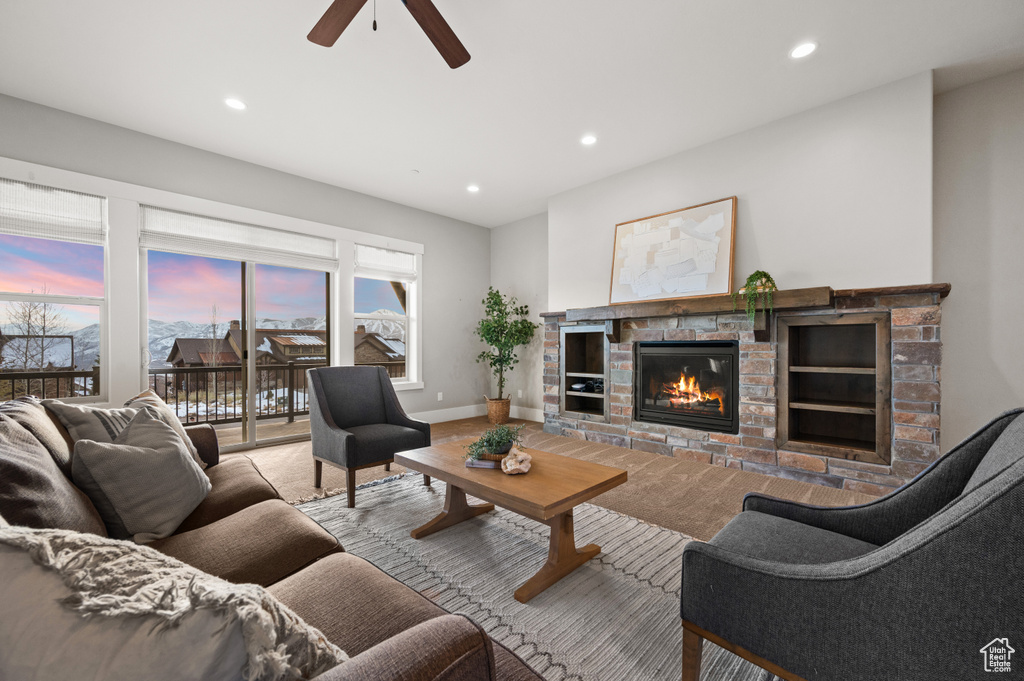Living room featuring carpet, baseboards, a ceiling fan, recessed lighting, and a glass covered fireplace
