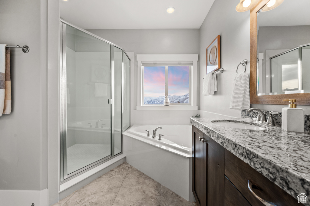 Full bathroom with tile patterned floors, a garden tub, vanity, and a shower stall