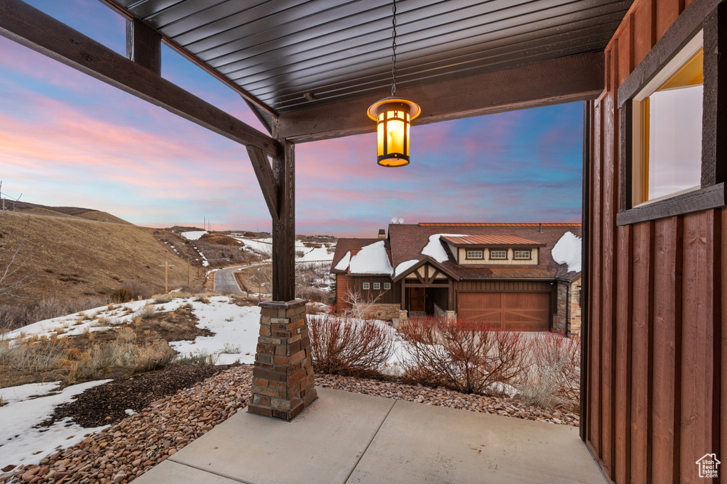 Snow covered patio with a mountain view