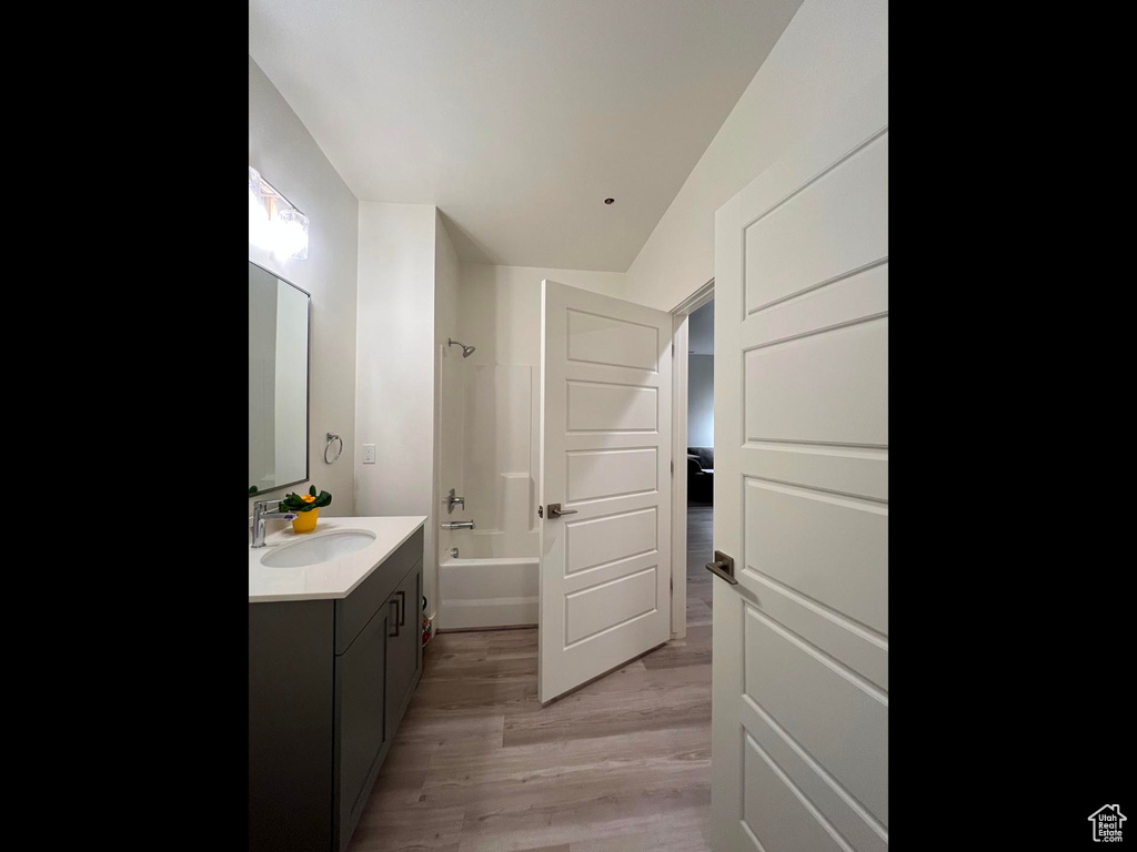 Bathroom with vanity,  shower combination, and wood finished floors