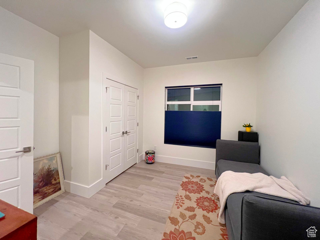 Bedroom with light wood-style floors, visible vents, and baseboards