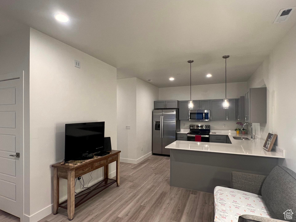 Kitchen featuring visible vents, gray cabinets, a sink, stainless steel appliances, and light countertops