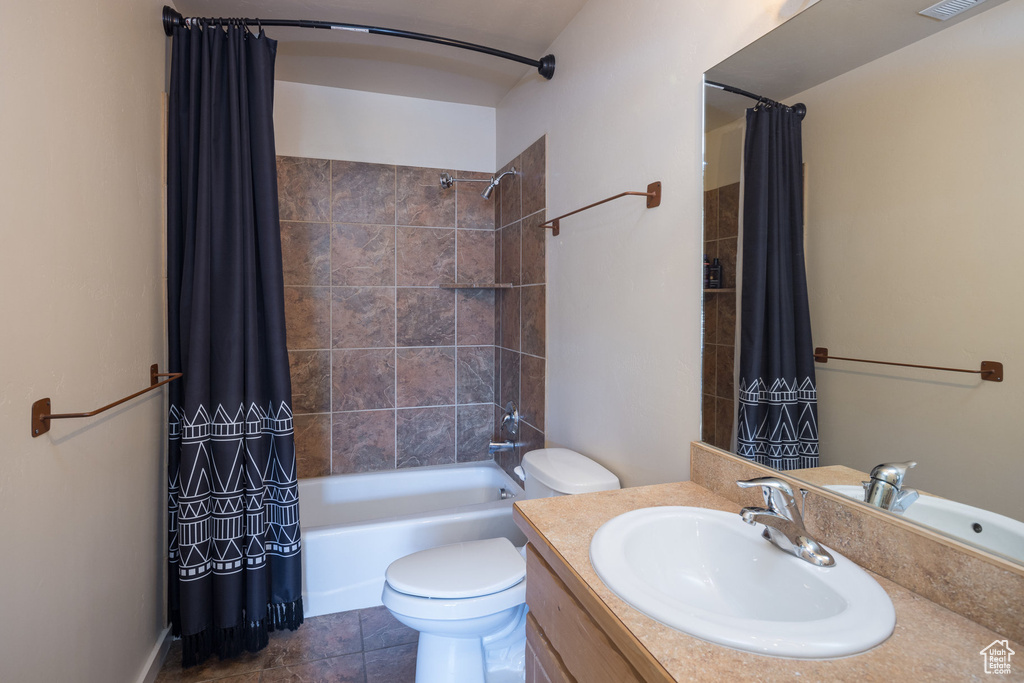 Bathroom featuring shower / bathtub combination with curtain, visible vents, toilet, tile patterned flooring, and vanity