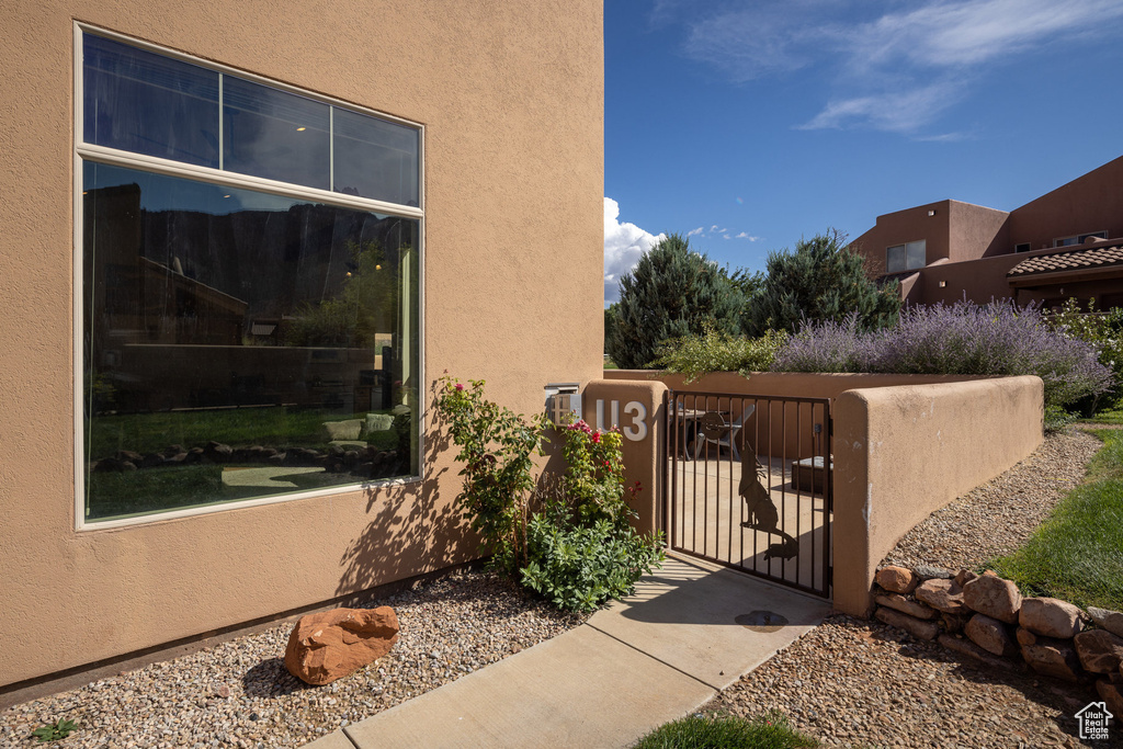 Exterior space featuring stucco siding, fence, and a gate