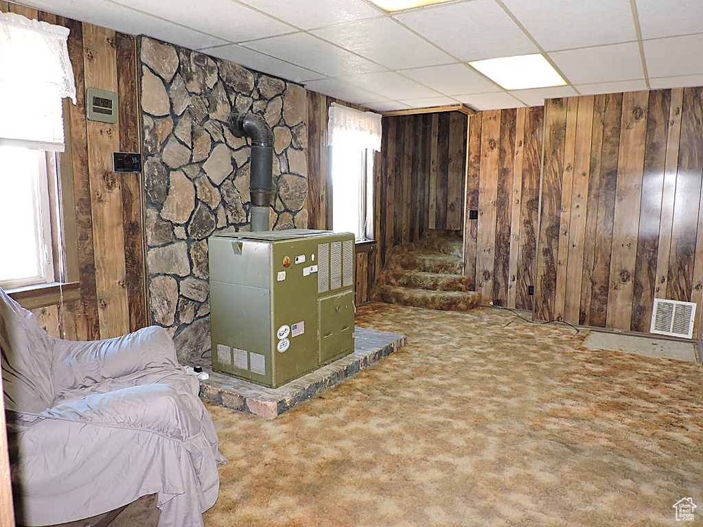 Basement featuring visible vents, wood walls, and a healthy amount of sunlight