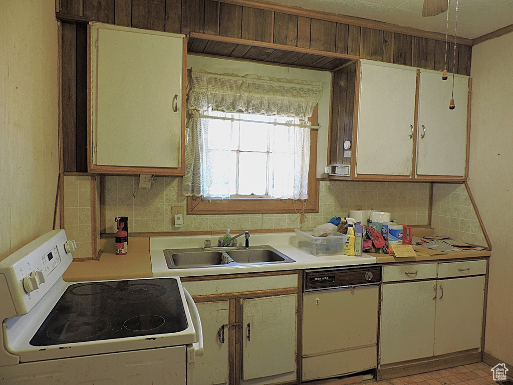 Kitchen featuring dishwasher, light countertops, decorative backsplash, white electric range, and a sink