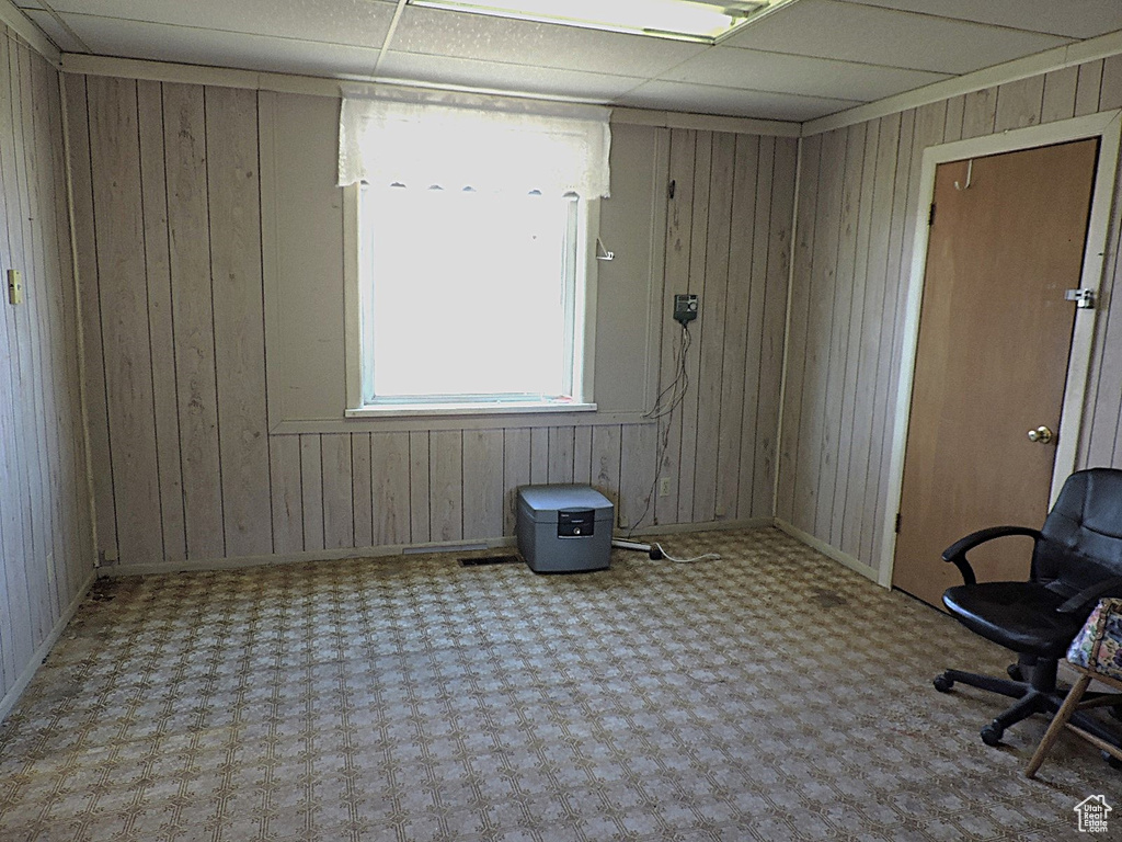 Spare room with wood walls and a paneled ceiling