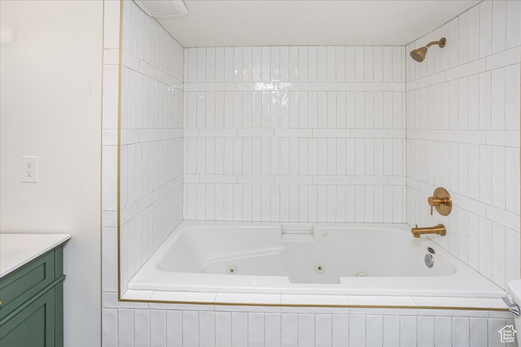 Full bathroom featuring visible vents, vanity, and a combined bath / shower with jetted tub