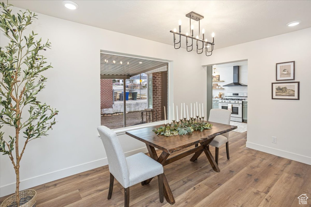 Dining area with recessed lighting, a notable chandelier, wood finished floors, and baseboards