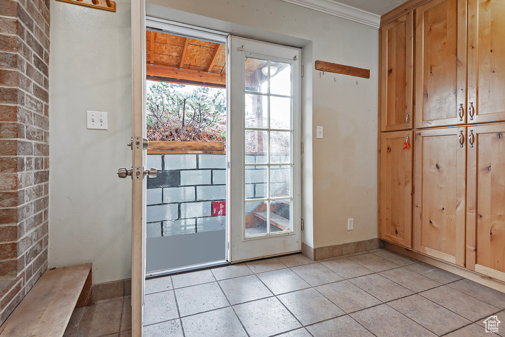 Entryway with crown molding and baseboards