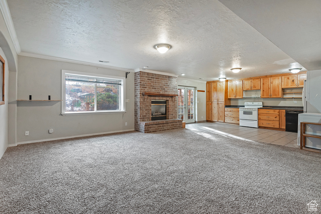 Unfurnished living room with light colored carpet, a brick fireplace, a textured ceiling, and ornamental molding