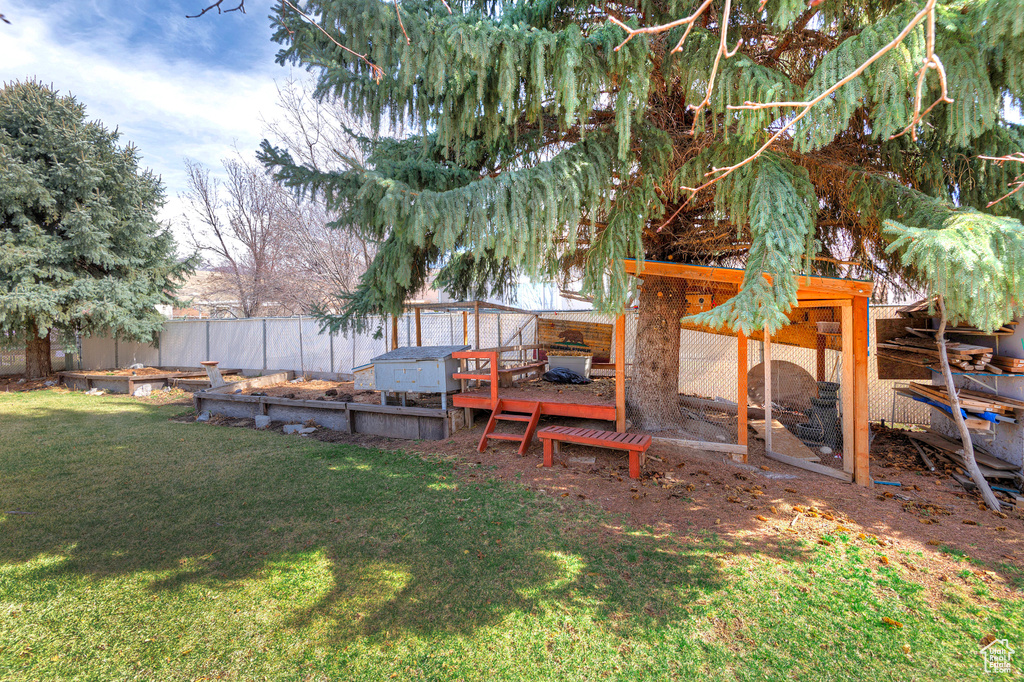 View of yard with an outbuilding, exterior structure, and fence