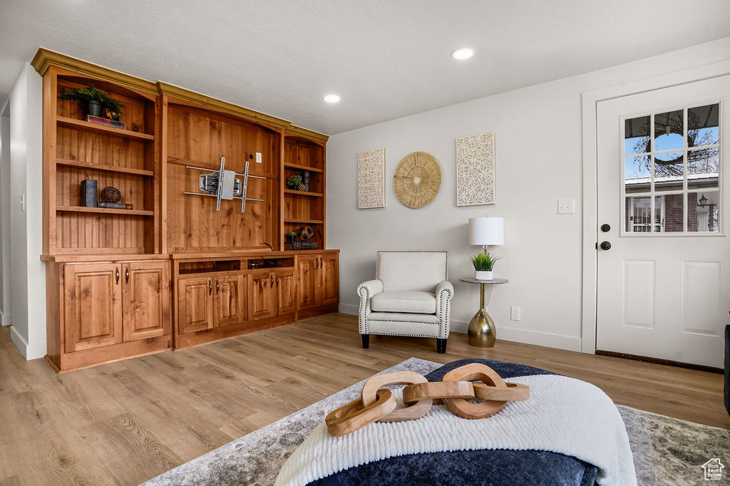 Living area with recessed lighting, baseboards, and light wood-style floors