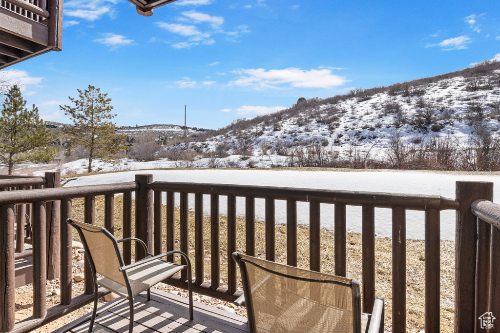Snow covered back of property with a mountain view