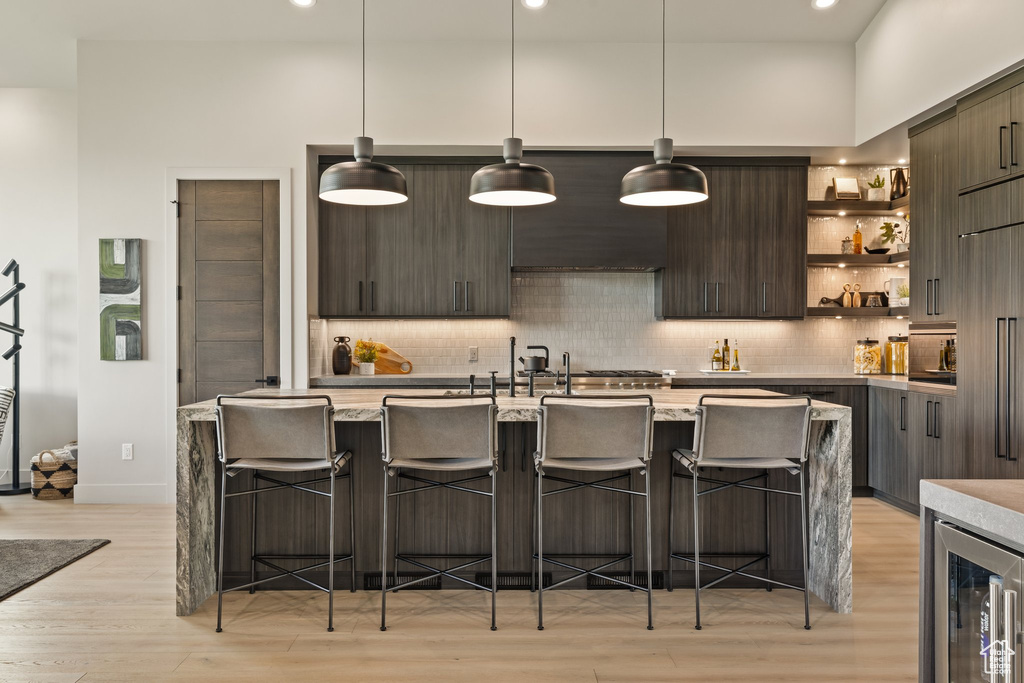 Kitchen with modern cabinets, light wood-style floors, decorative backsplash, open shelves, and recessed lighting