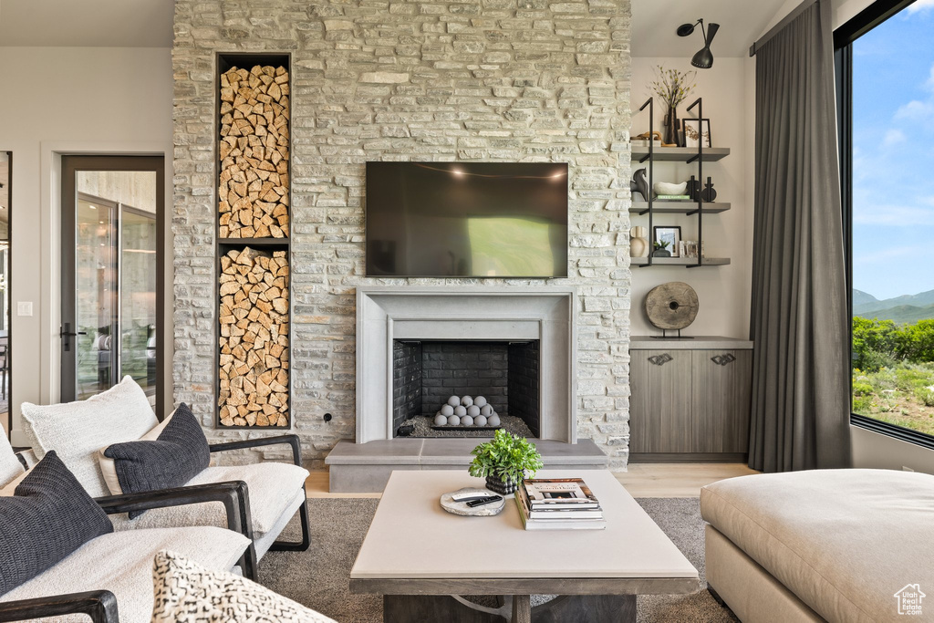 Living area featuring wood finished floors and a fireplace with raised hearth