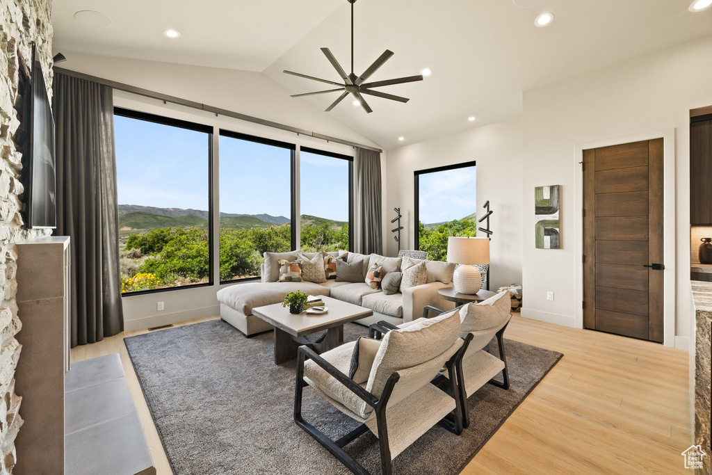 Living area featuring light wood finished floors, lofted ceiling, a ceiling fan, recessed lighting, and a mountain view