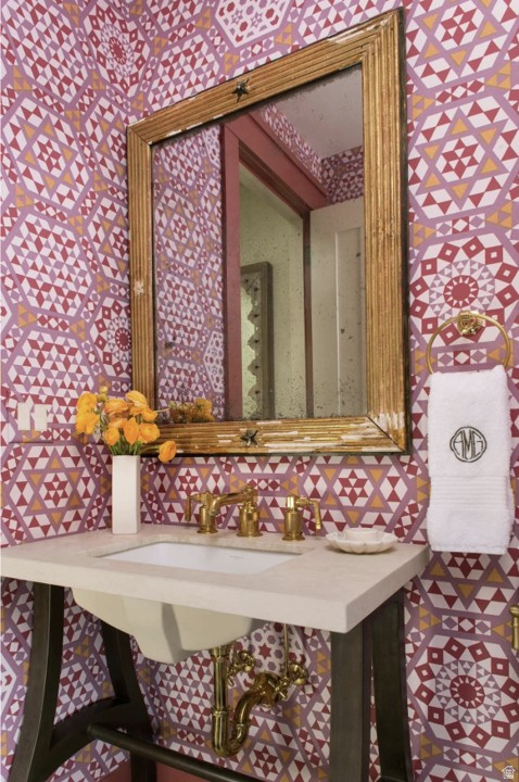 Bathroom featuring wallpapered walls and a sink