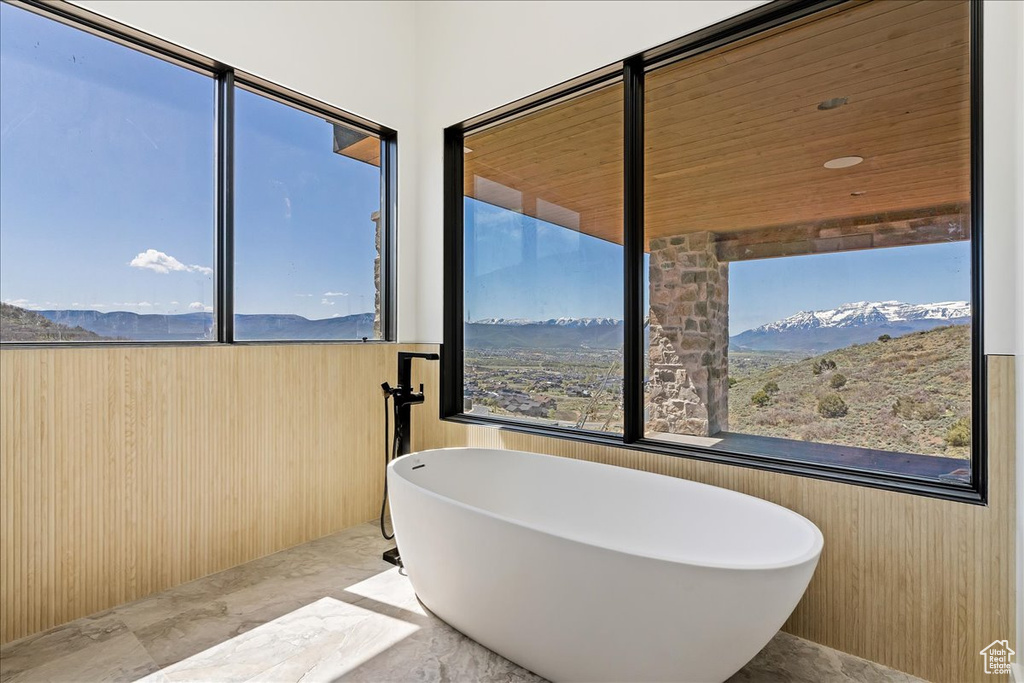 Bathroom featuring a freestanding tub, marble tiled flooring, and a mountain view