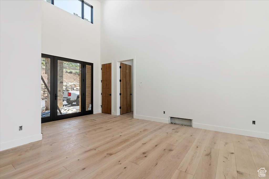 Foyer entrance featuring plenty of natural light, baseboards, hardwood / wood-style flooring, and a high ceiling