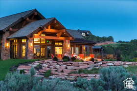 Back of property featuring an outdoor fire pit and stone siding