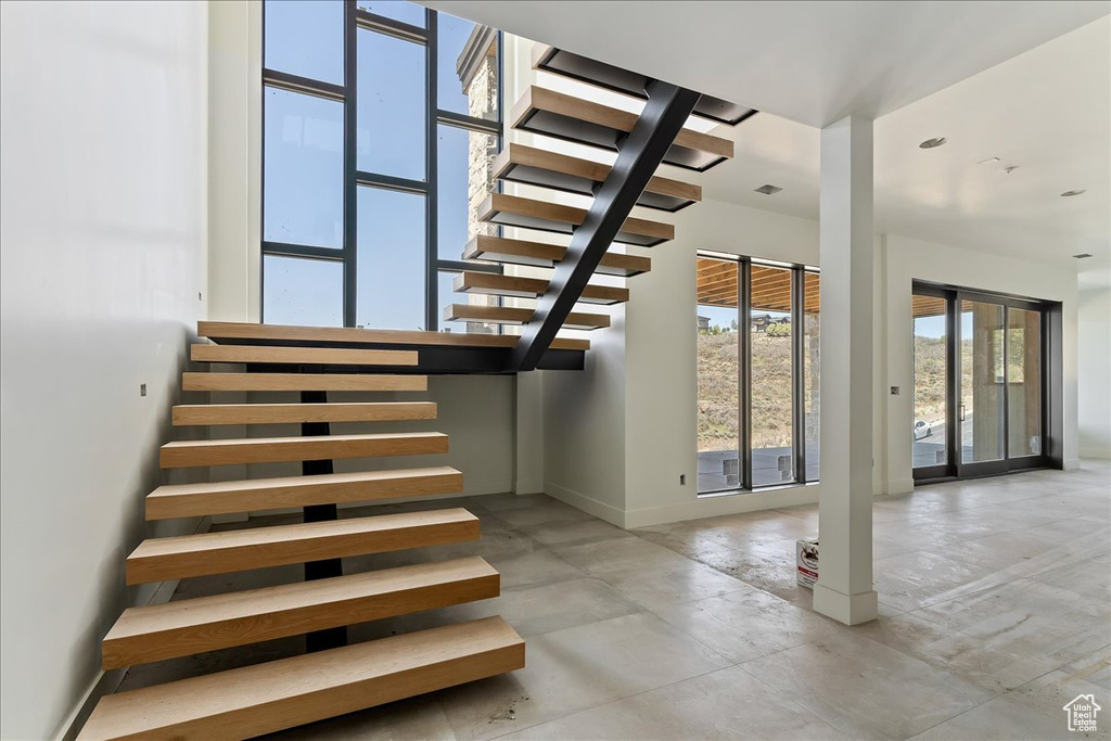 Staircase with concrete flooring and baseboards