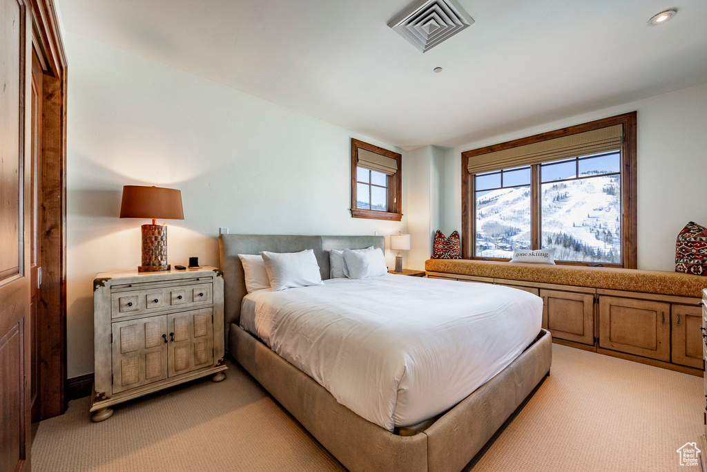 Bedroom with light colored carpet and visible vents