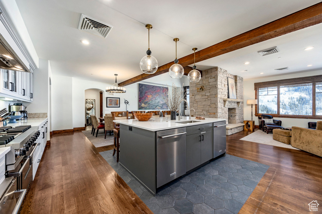 Kitchen with arched walkways, stainless steel appliances, open floor plan, and visible vents