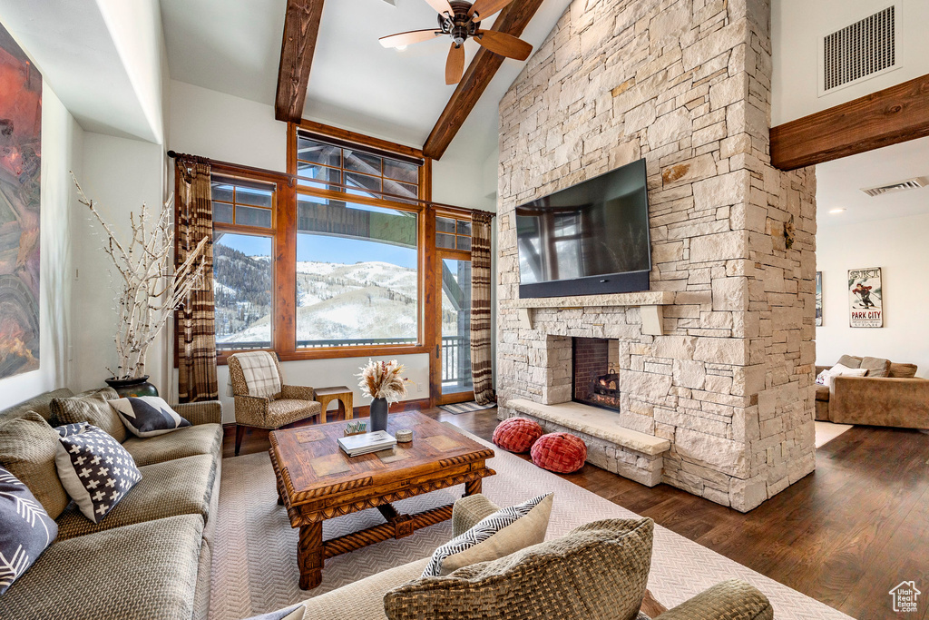 Living room with visible vents, a ceiling fan, beam ceiling, and wood finished floors