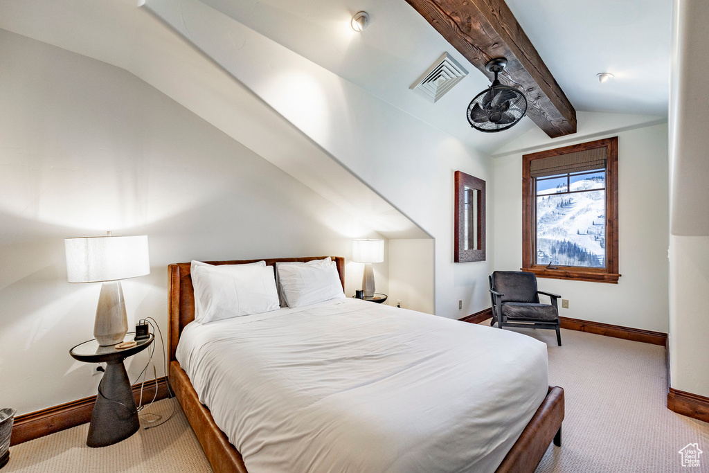 Carpeted bedroom with baseboards, visible vents, and vaulted ceiling with beams