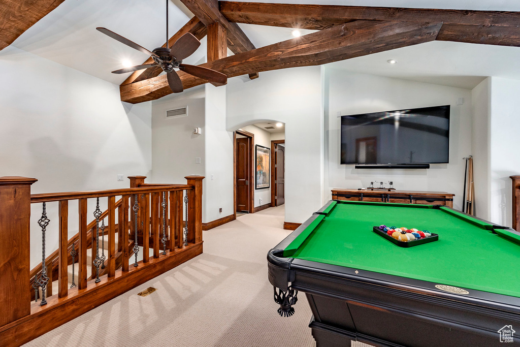 Playroom featuring ceiling fan, visible vents, arched walkways, carpet floors, and vaulted ceiling with beams