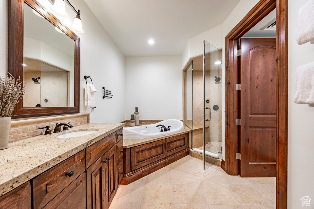 Bathroom featuring backsplash, a garden tub, a shower stall, vanity, and recessed lighting