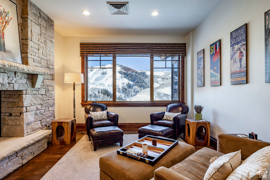 Living room featuring dark wood-style flooring, visible vents, baseboards, a mountain view, and recessed lighting