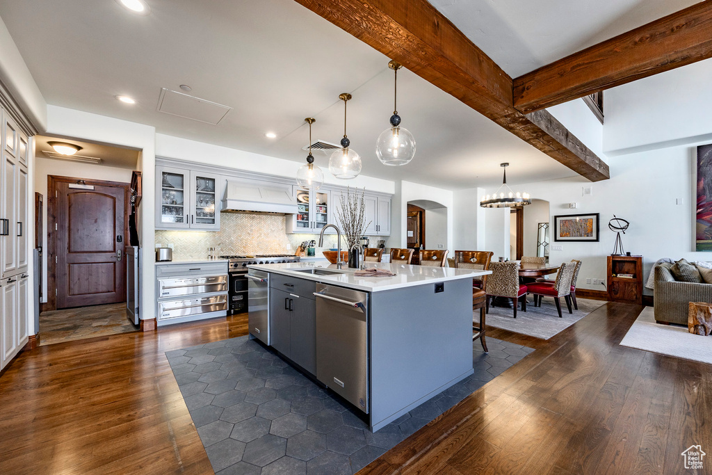 Kitchen featuring arched walkways, a breakfast bar, dark wood-type flooring, and dishwasher