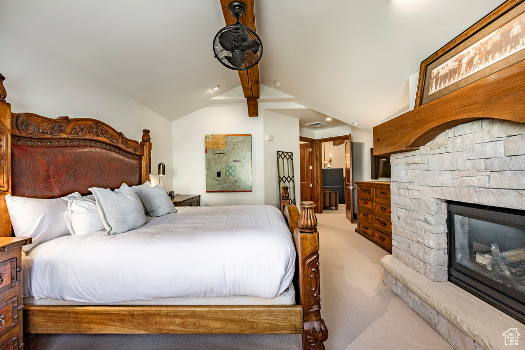 Bedroom featuring ensuite bathroom, a stone fireplace, light colored carpet, vaulted ceiling with beams, and recessed lighting