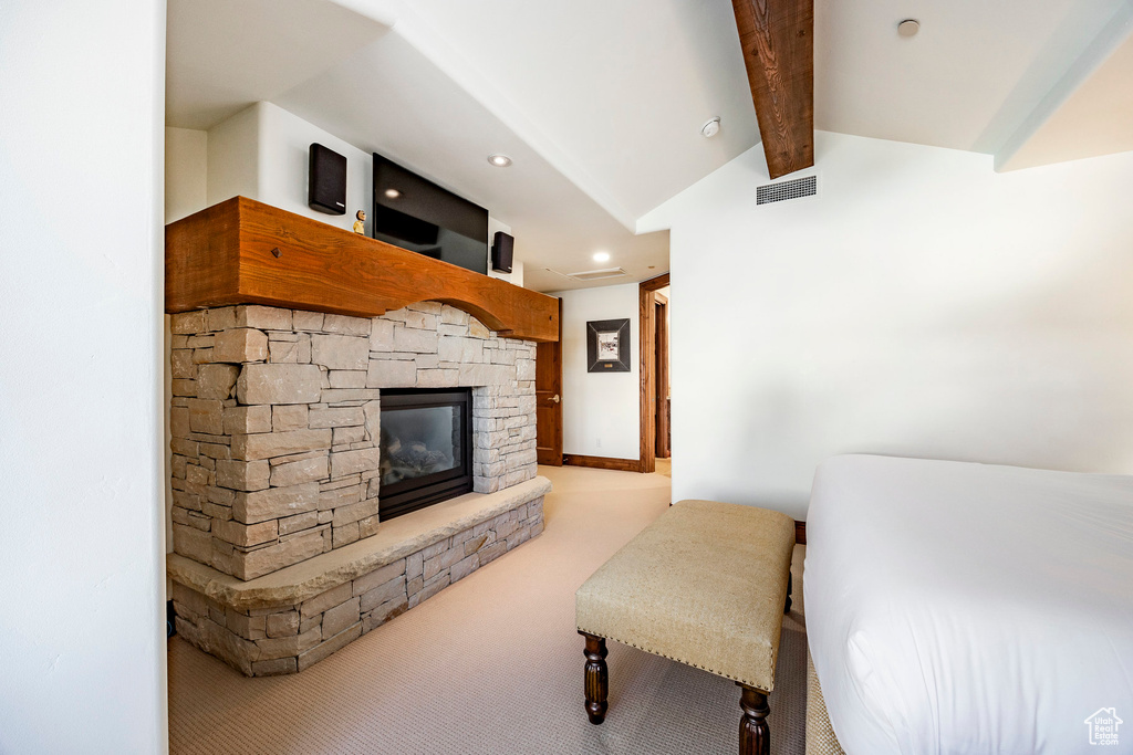Carpeted bedroom with recessed lighting, a stone fireplace, visible vents, and lofted ceiling with beams