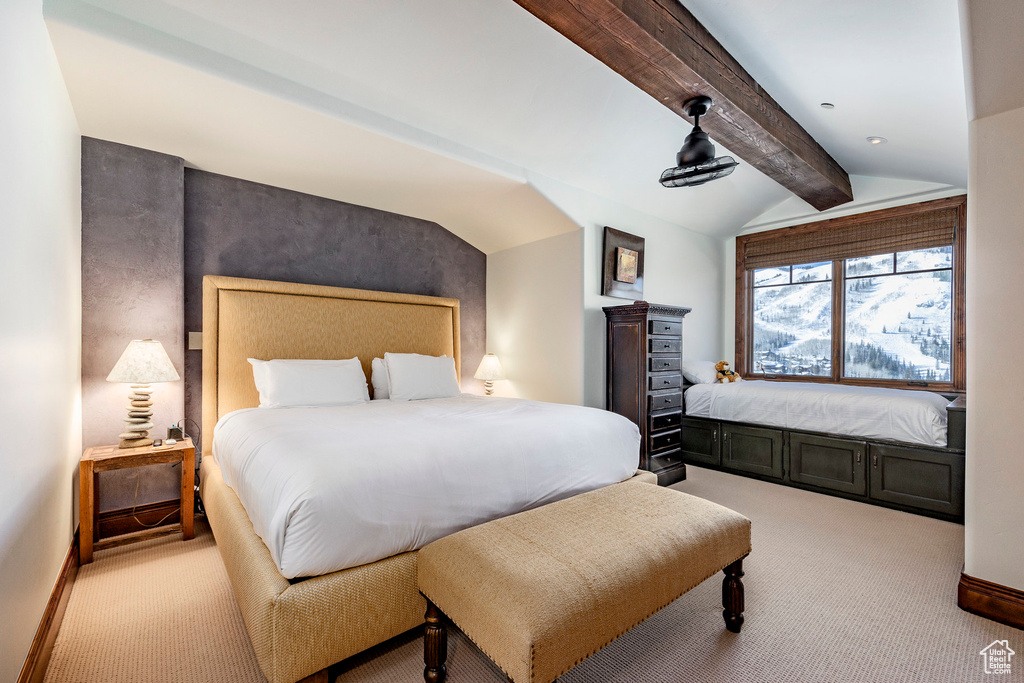 Bedroom featuring baseboards, lofted ceiling with beams, and carpet