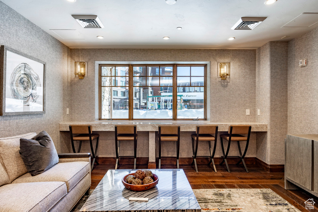 Living area featuring wood-type flooring, recessed lighting, wallpapered walls, and visible vents