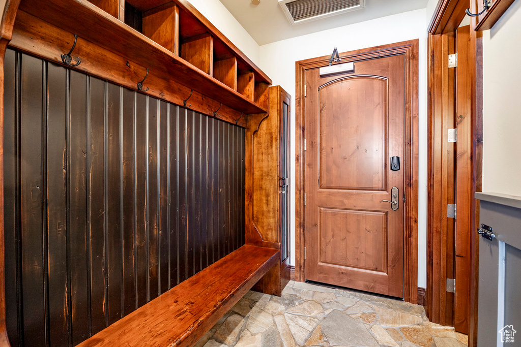 Mudroom featuring stone finish floor and visible vents