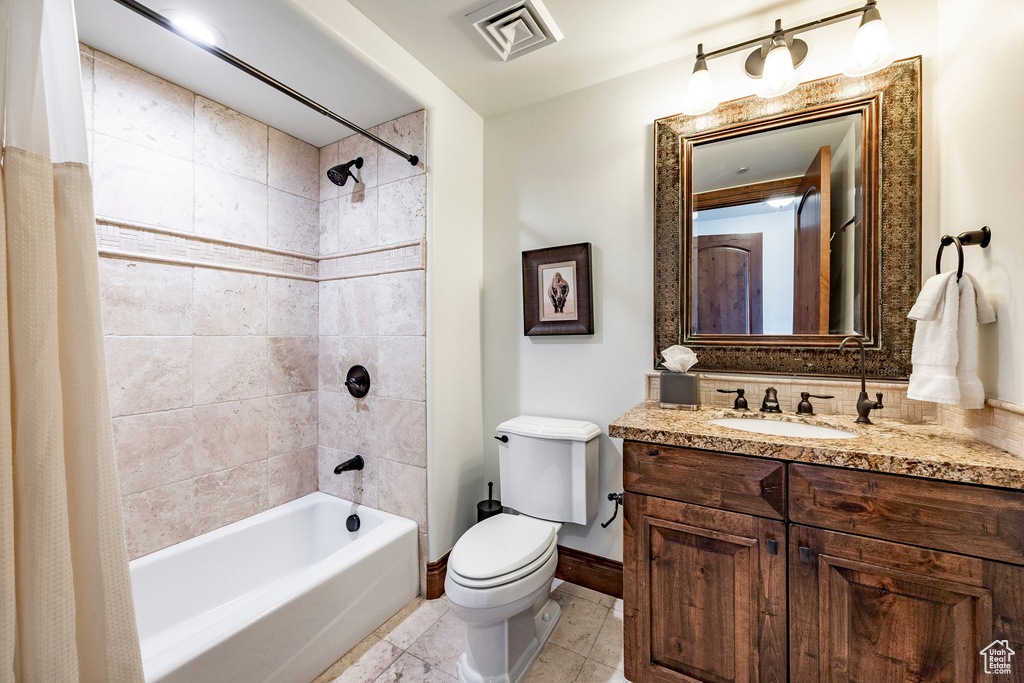 Bathroom with tile patterned flooring, vanity, toilet, shower / tub combo, and visible vents