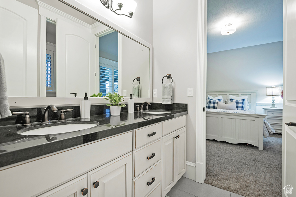 Full bathroom with ensuite bath, tile patterned floors, and double vanity