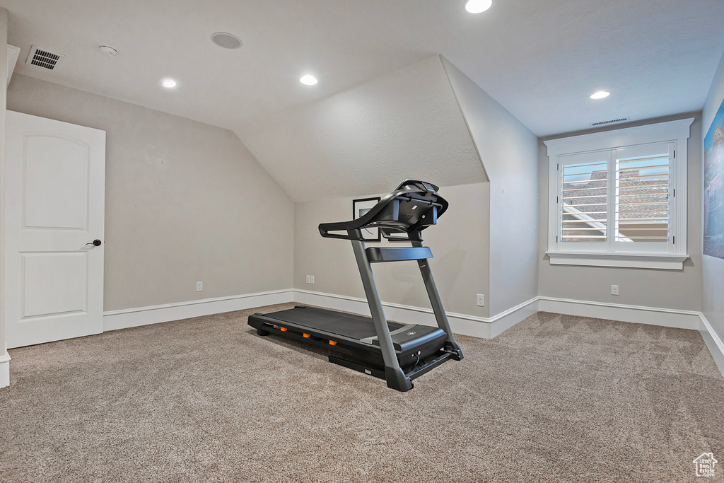 Workout area featuring carpet floors, baseboards, lofted ceiling, and recessed lighting